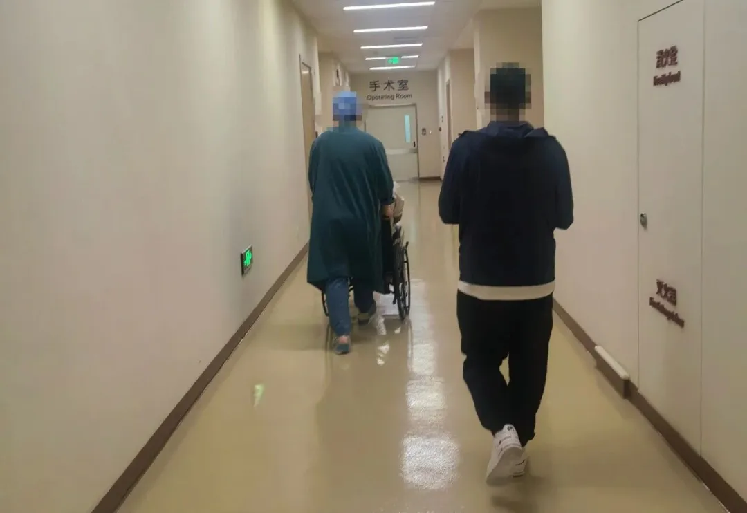 Patient being escorted to operating room at Beijing Edencare Hospital — showing clean, modern hospital corridor
