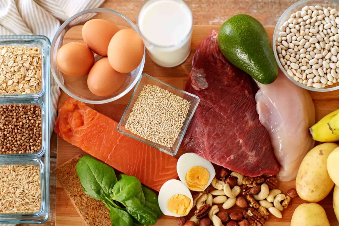 A balanced selection of high-protein, nutrient-dense foods: eggs, lean meats, salmon, avocado, nuts, whole grains and vegetables